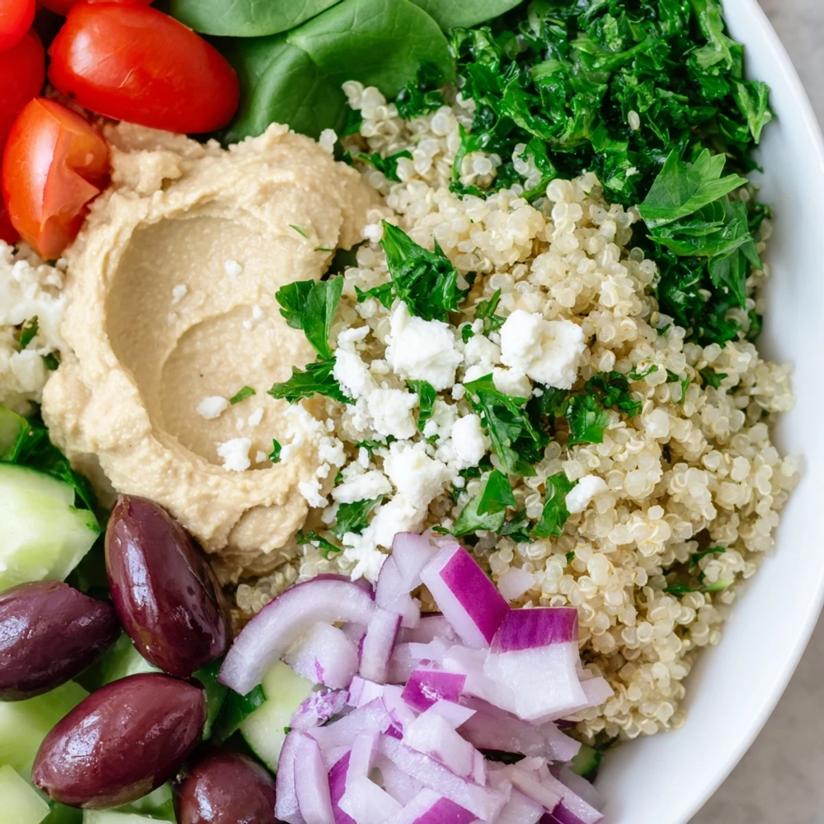 Colorful Mediterranean Quinoa Bowl with fluffy quinoa, crisp cucumbers, juicy tomatoes, and a dollop of hummus ready to enjoy.