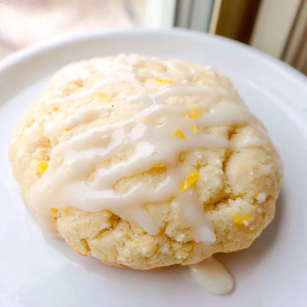 Glazed Lemon Ricotta Cookies resting on a cooling rack with lemon wedges nearby for serving.
