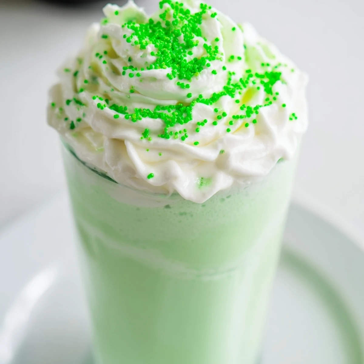 Rich, cool Shamrock Mint Milkshake blended with vanilla ice cream, poured into glasses for a festive St. Patrick’s Day treat.