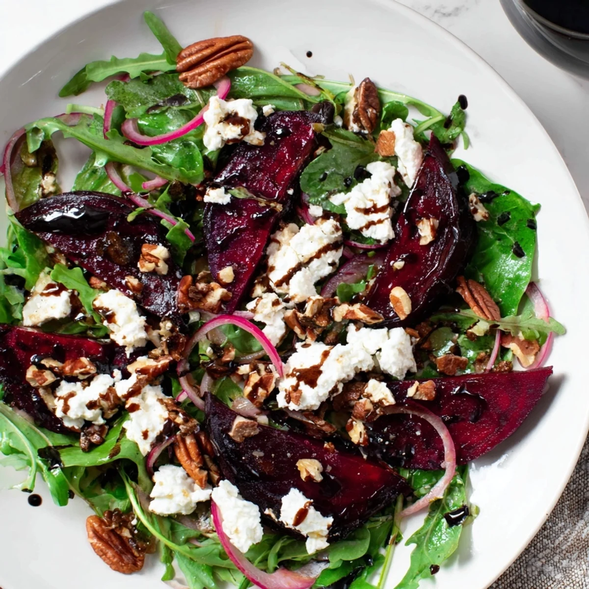 Vibrant roasted beet and goat cheese salad with crunchy pecans and a tangy dressing, served as a light vegetarian main.  