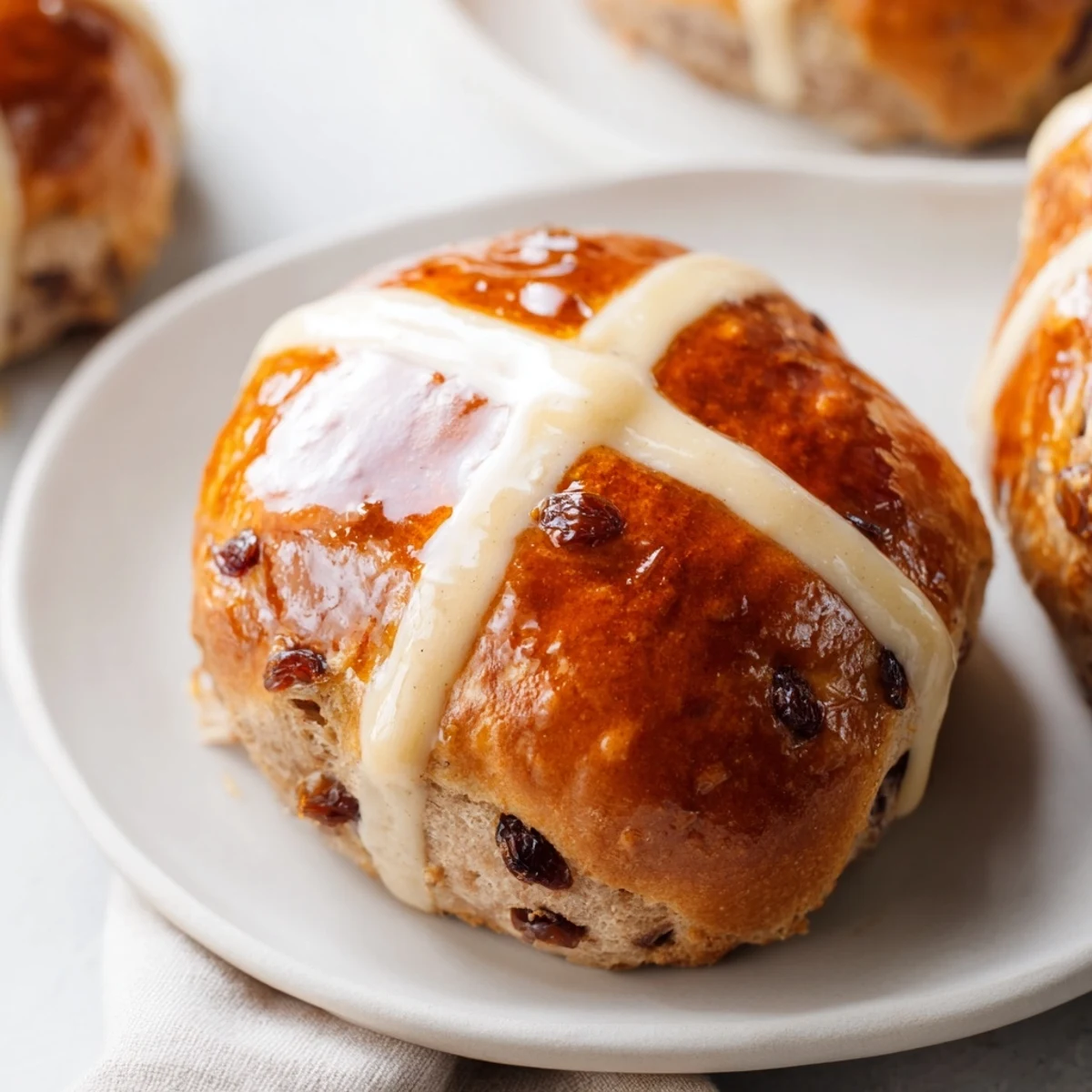 Freshly baked Hot Cross Buns with currants and spices, paired with a cup of tea for breakfast.