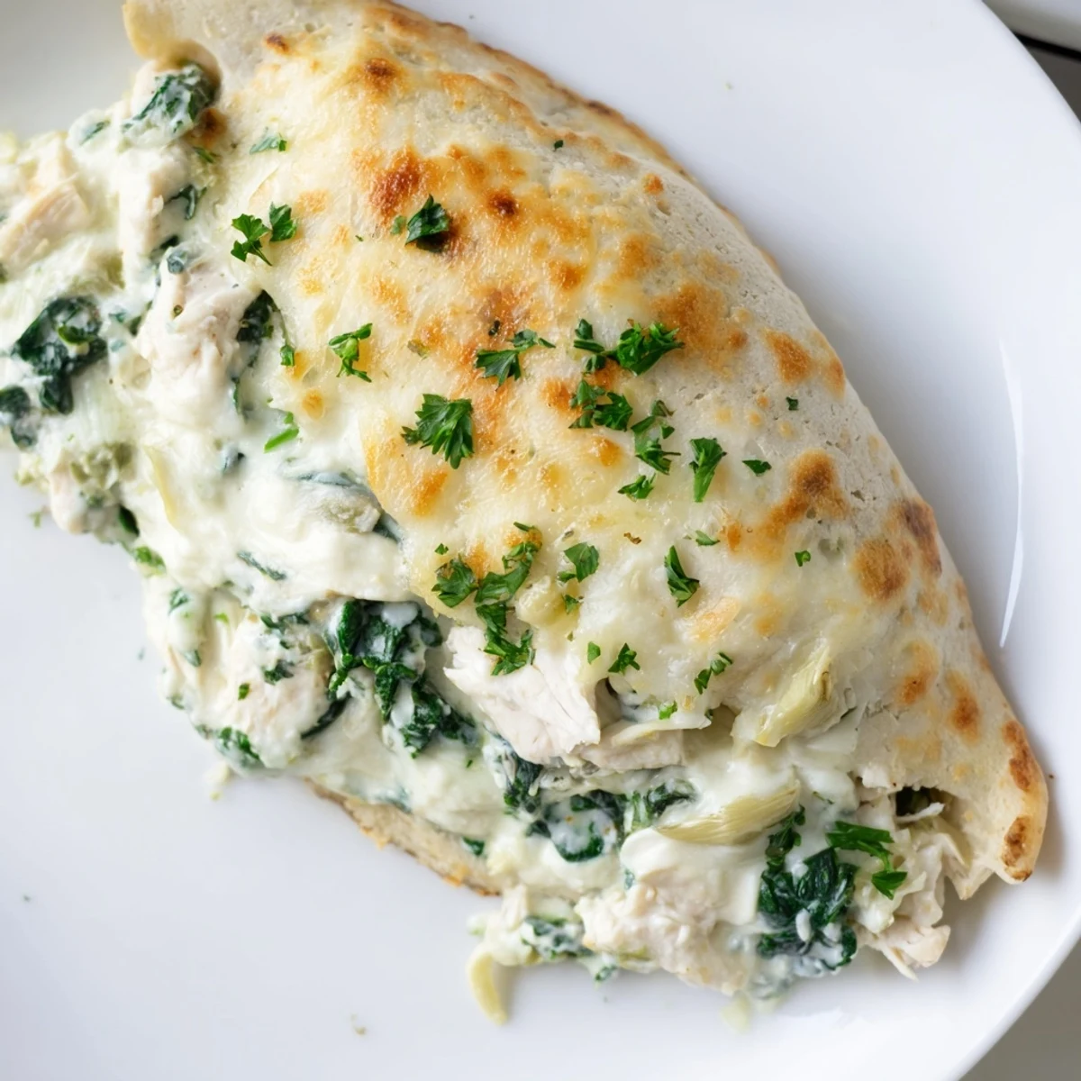 Succulent Creamy Spinach and Artichoke Stuffed Chicken Breast served alongside a fresh green salad and roasted vegetables.