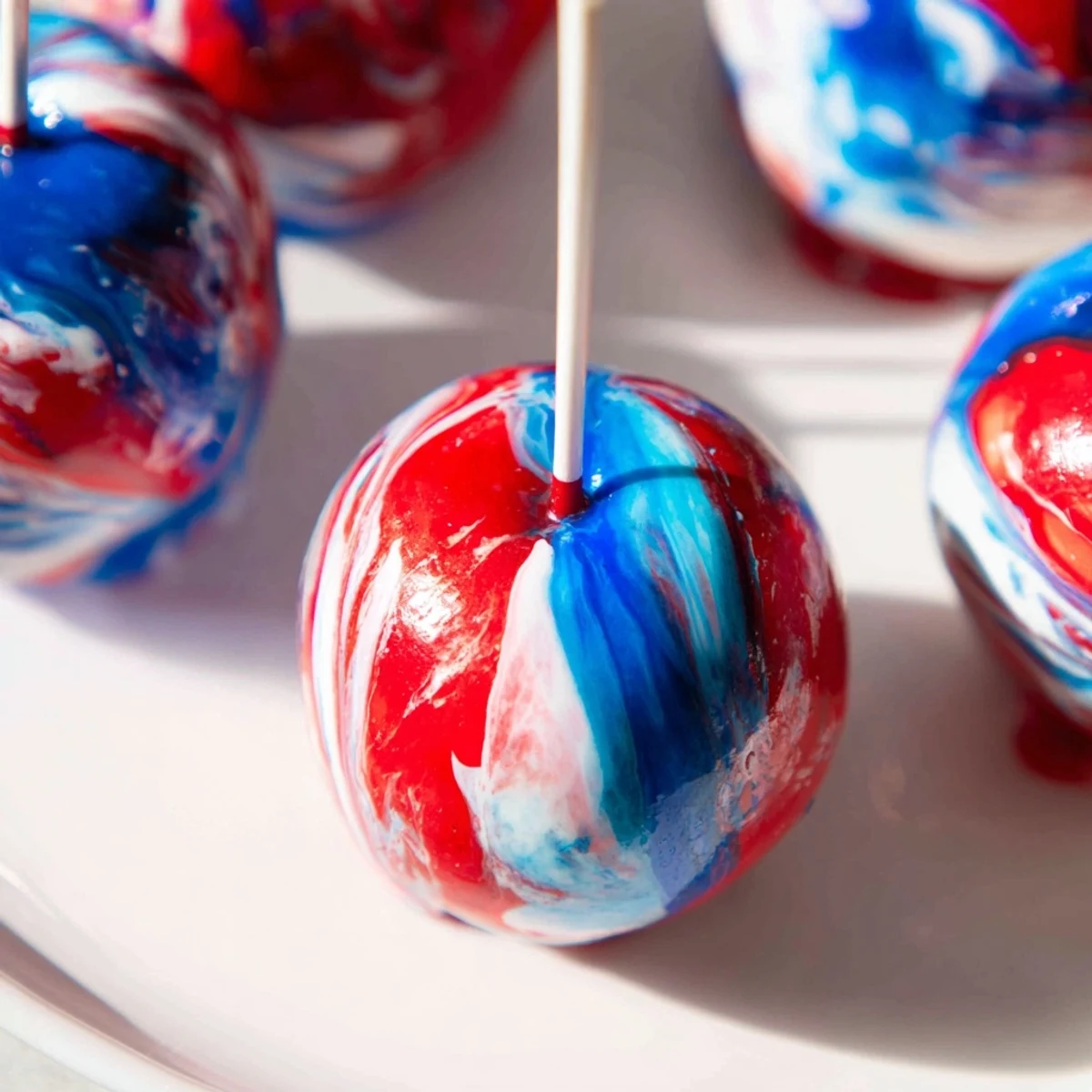 Perfectly coated marbled effect candy apples on sticks, ready for a festive American fall party or holiday gathering.