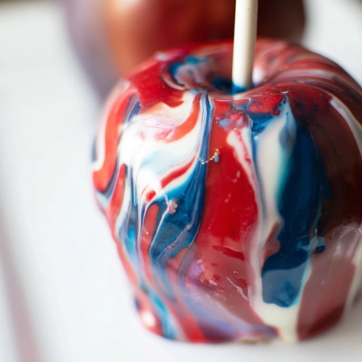 Stunning marbled effect candy apples display, showing crisp green apples with a vibrant, glossy, swirled candy coating.