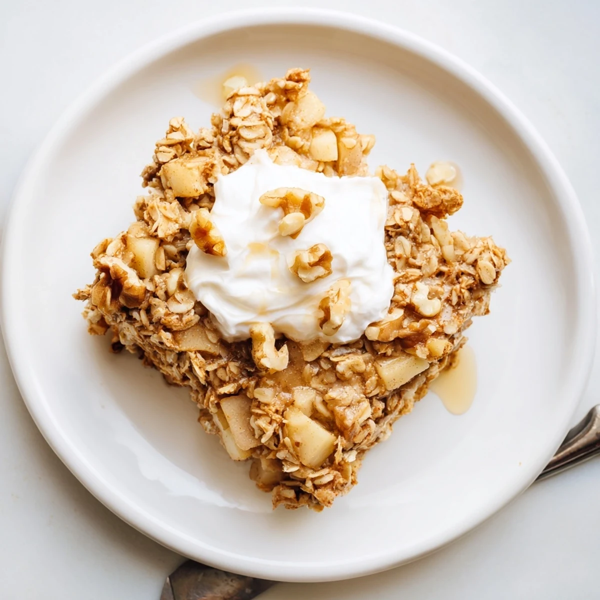 This Baked Apple Oatmeal with Greek Yogurt shows warm, tender oats with sweet apples and a drizzle of maple syrup.  