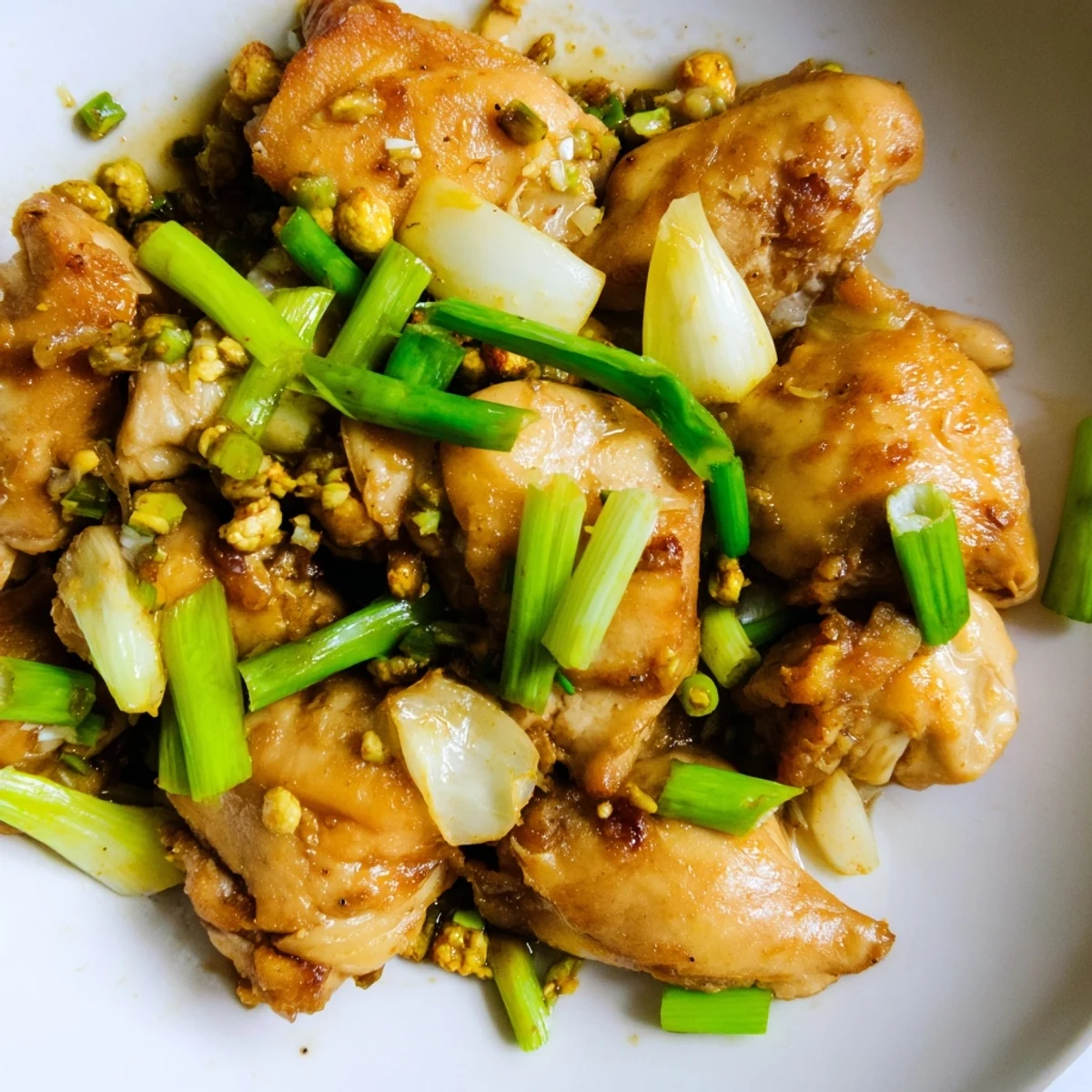 A close-up of colorful Vietnamese Lemongrass Chicken glistening with aromatic garlic and lemongrass marinade, ready to serve hot.