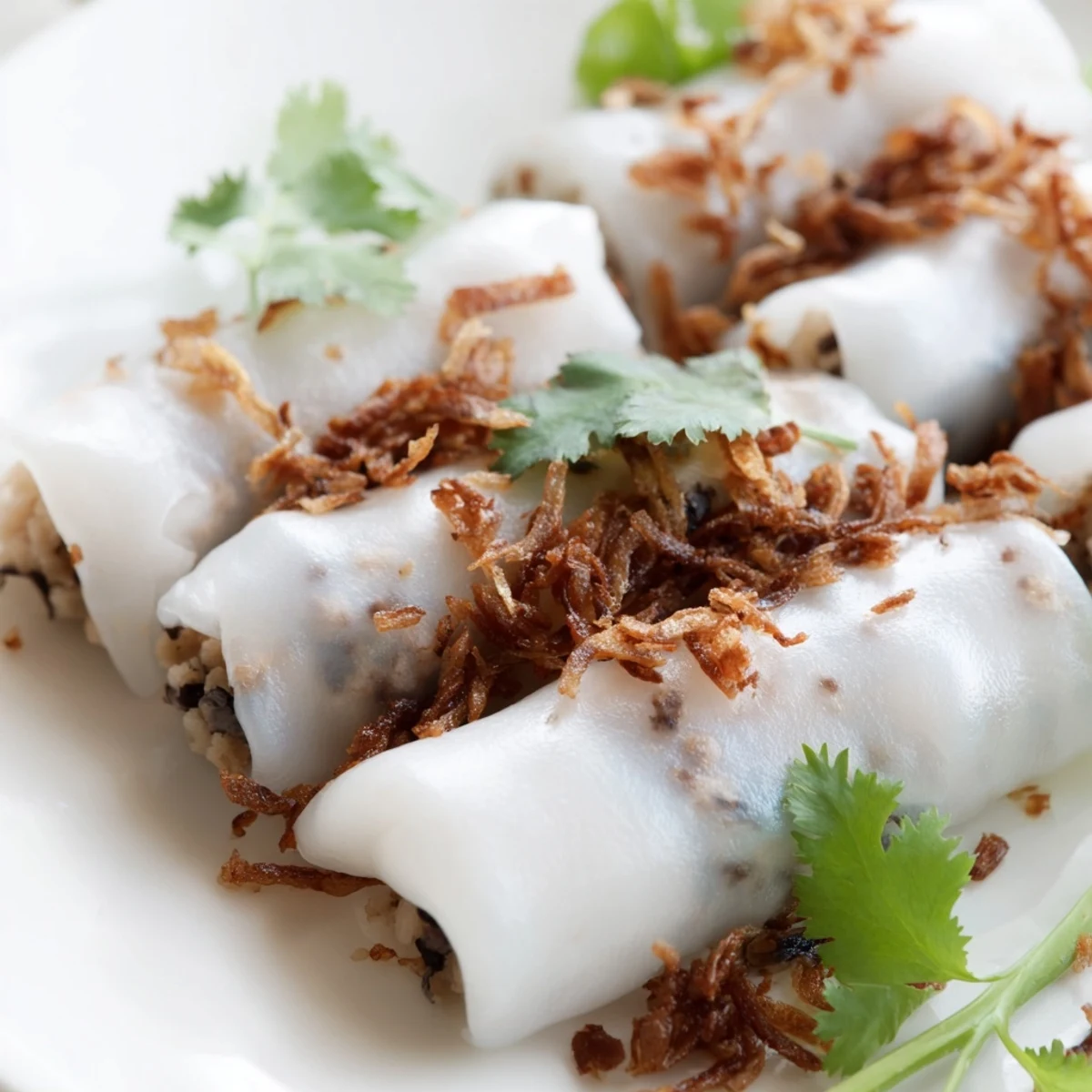 Serving Banh Cuon with fresh herbs, cucumber, and bean sprouts for a bright, classic Vietnamese breakfast snack.