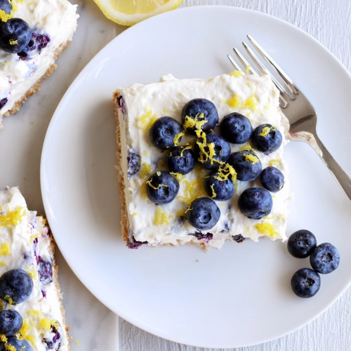 Slice of lemon blueberry cream cake showing swirled filling and whole blueberries on crumbly golden crust