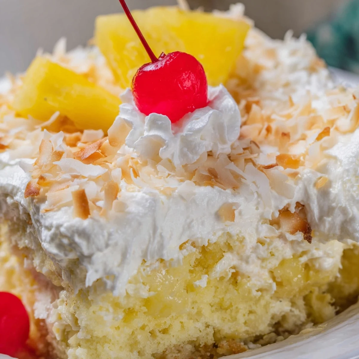 Golden yellow Hawaiian Poke Cake drizzled with creamy milk filling and finished with sweet coconut flakes