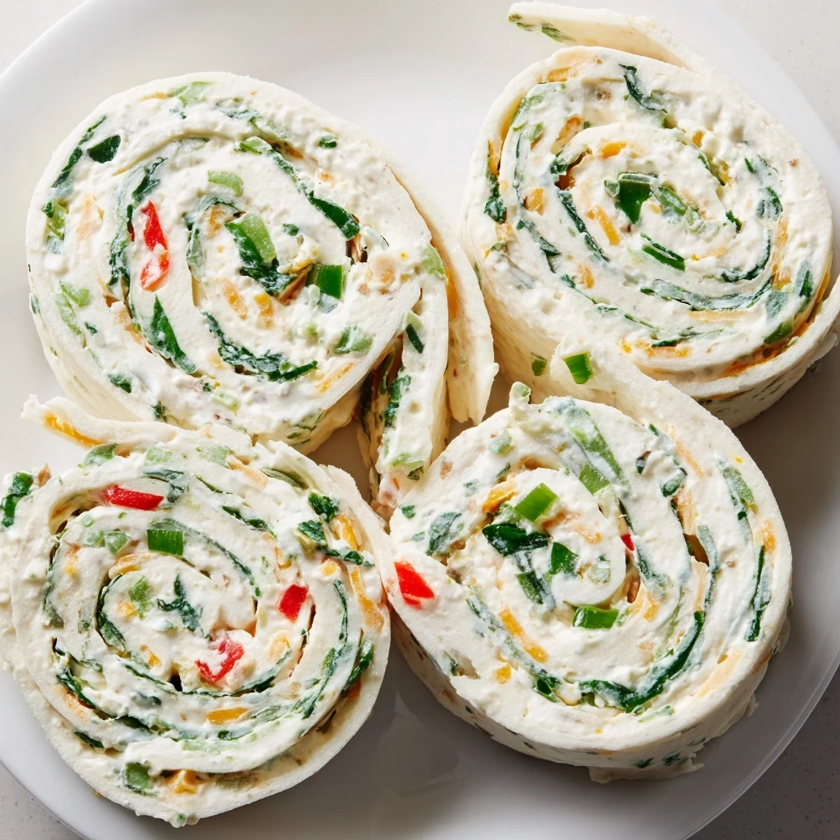 Cream cheese pinwheels arranged on a serving platter with fresh parsley garnish