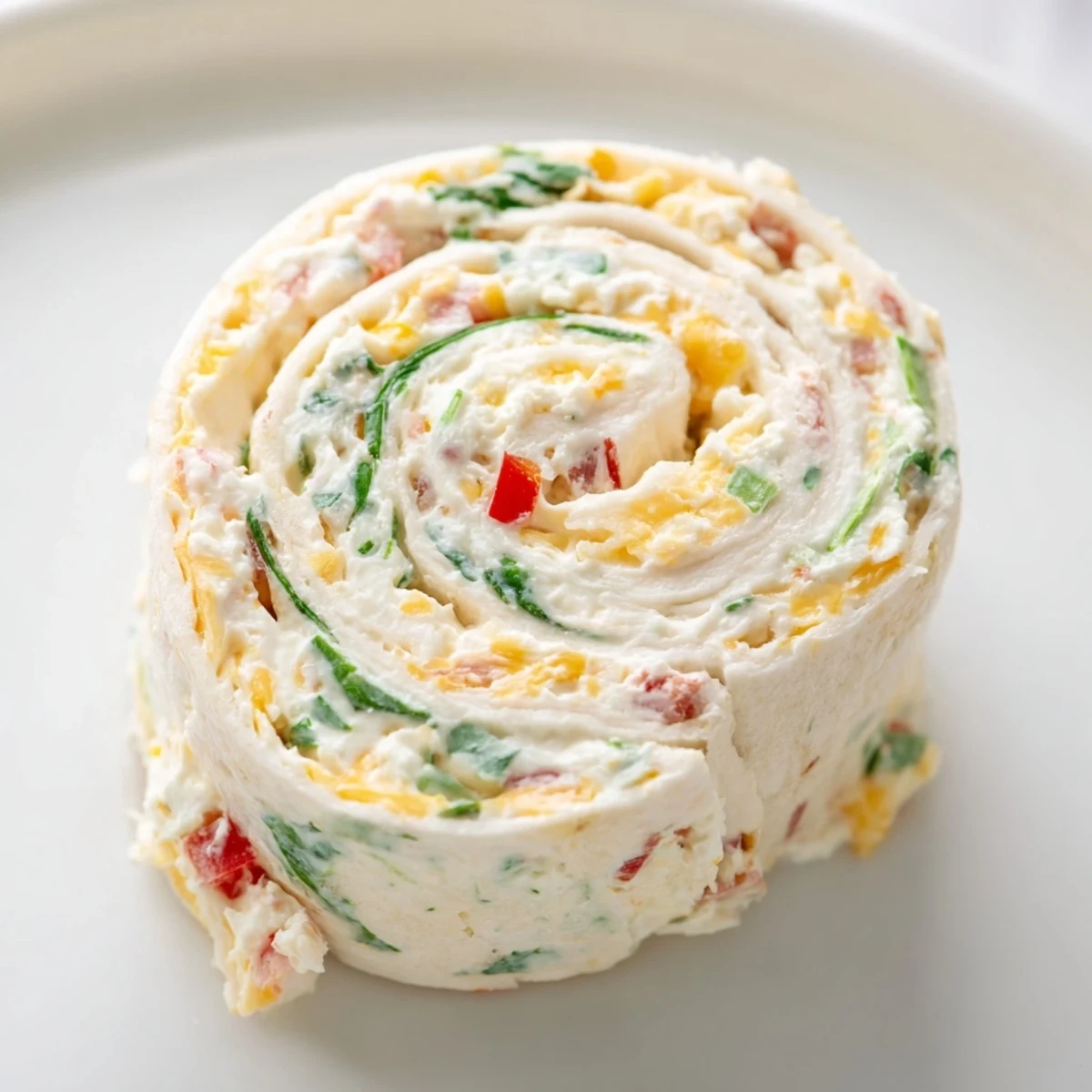 Rolled tortilla pinwheels with creamy herb and cheese filling ready for party serving