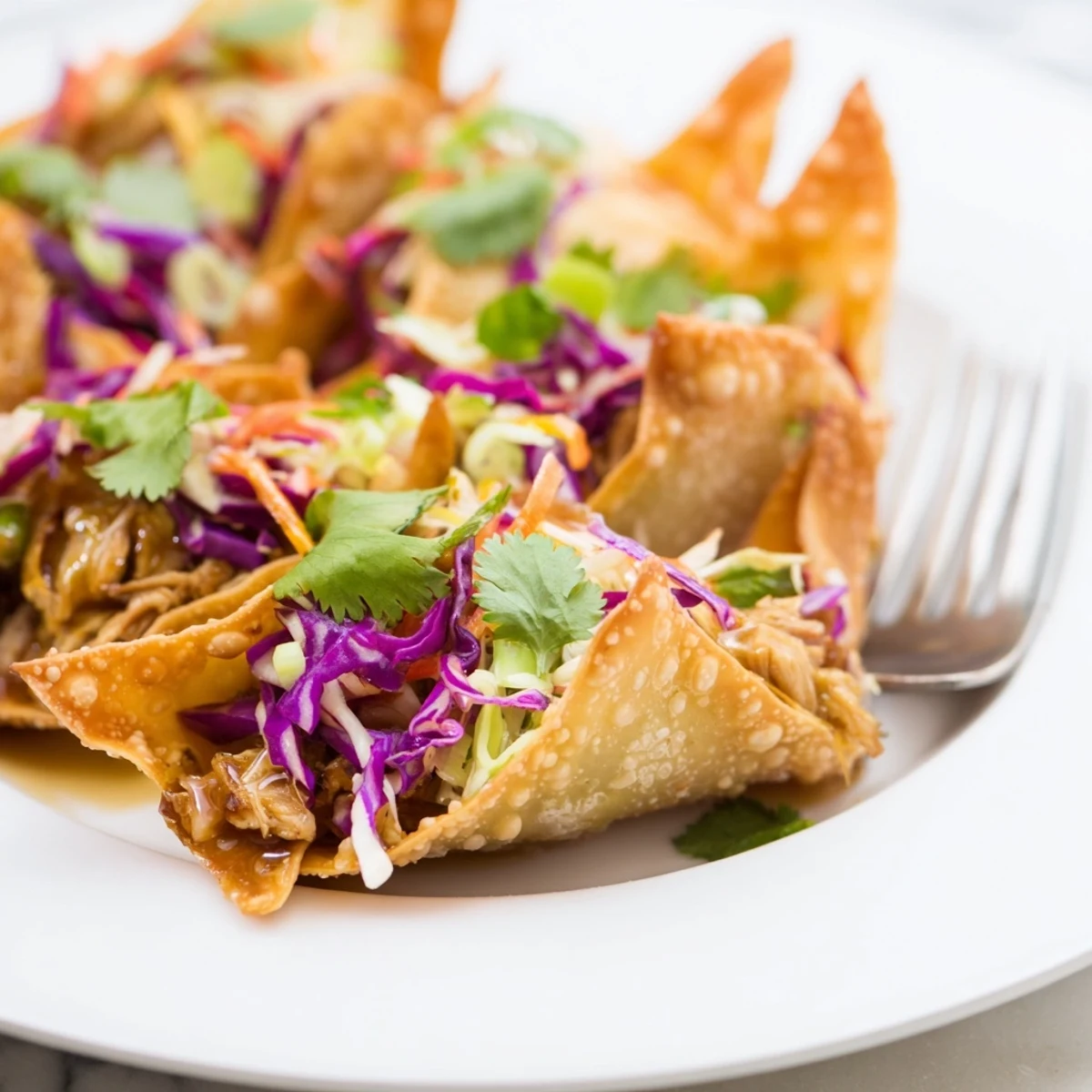 Homemade Asian fusion tacos showing baked wonton shells filled with tender chicken pieces and fresh vegetable slaw garnished with cilantro