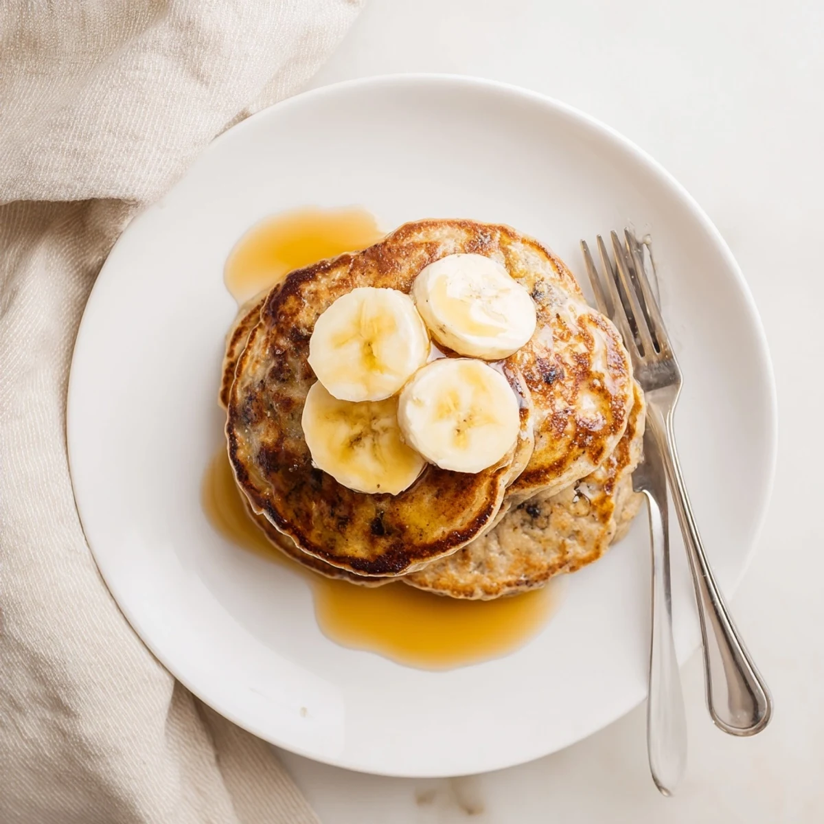 Steam rising from a warm stack of Greek yogurt banana pancakes topped with butter and blueberries