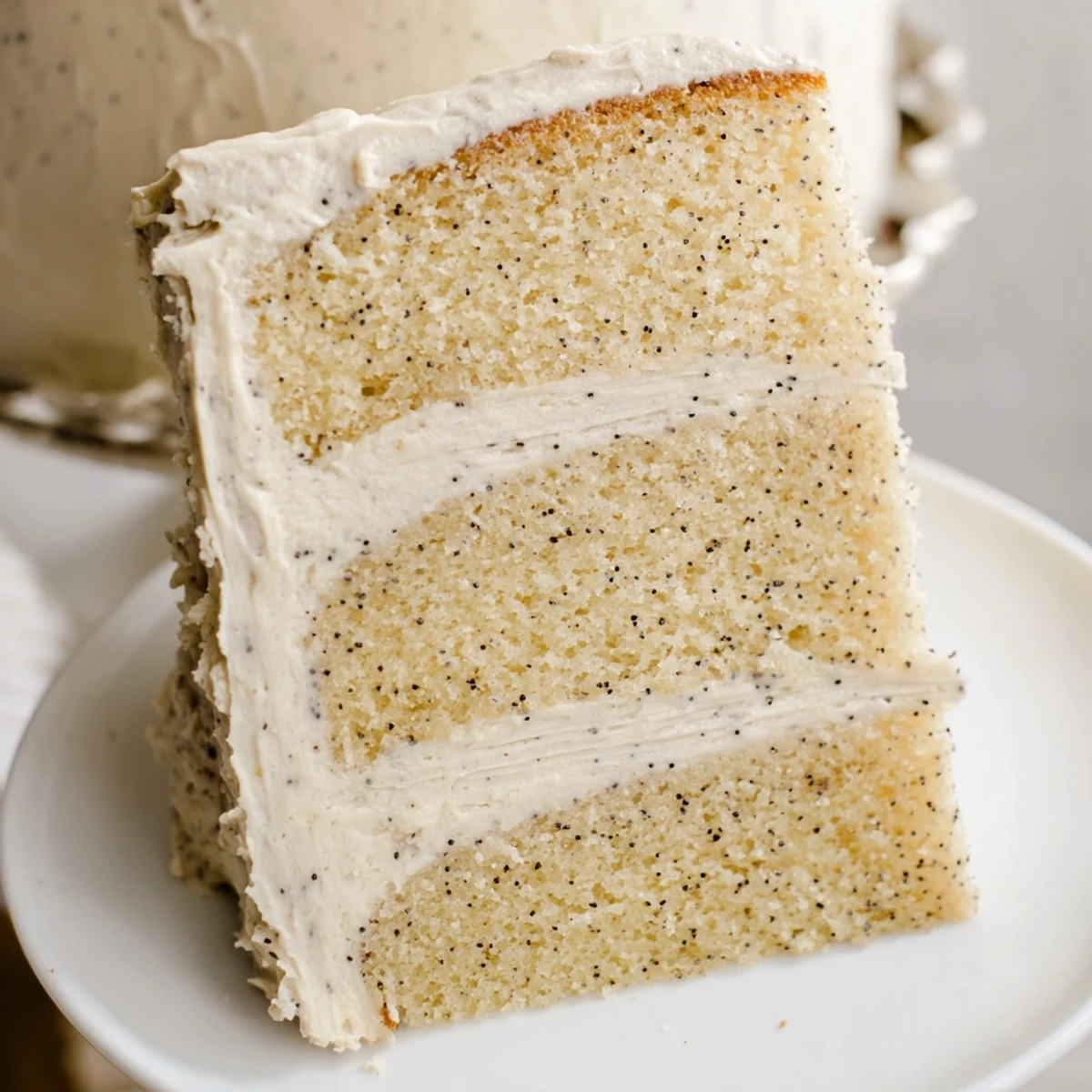 Vanilla bean birthday cake recipe showing frosted layered dessert with vanilla bean speckles throughout the golden cake
