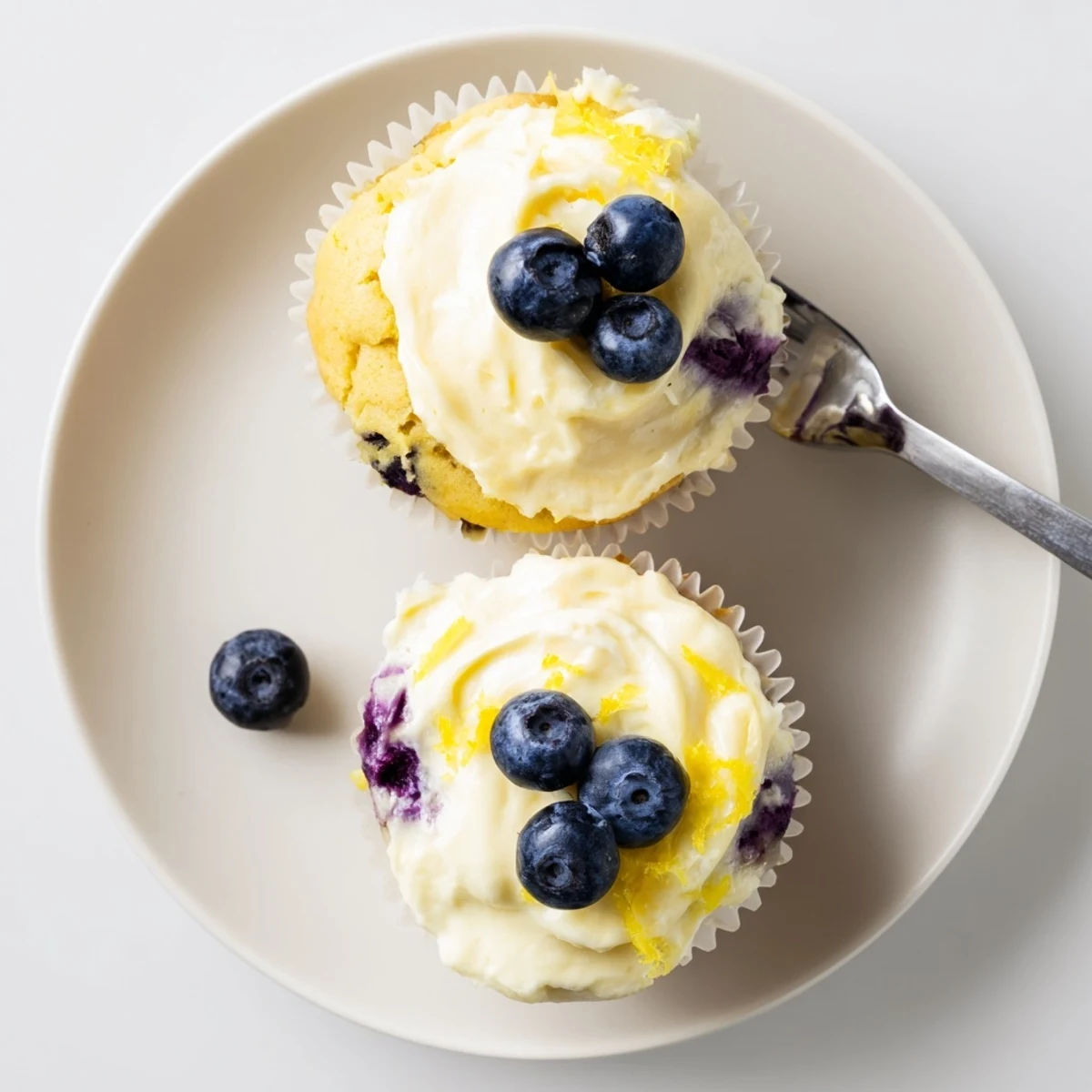 Summer dessert of lemon blueberry cupcakes with zesty frosting and scattered blueberries