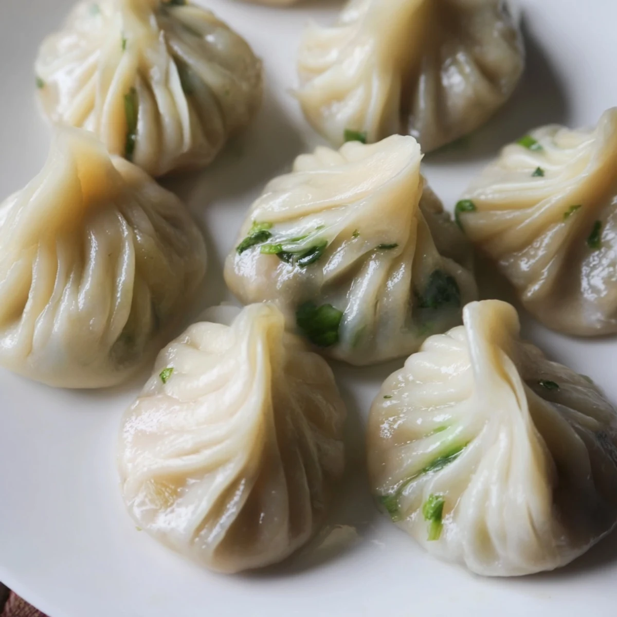 Golden Nepali momo dumplings with pleated edges served alongside vibrant red chutney