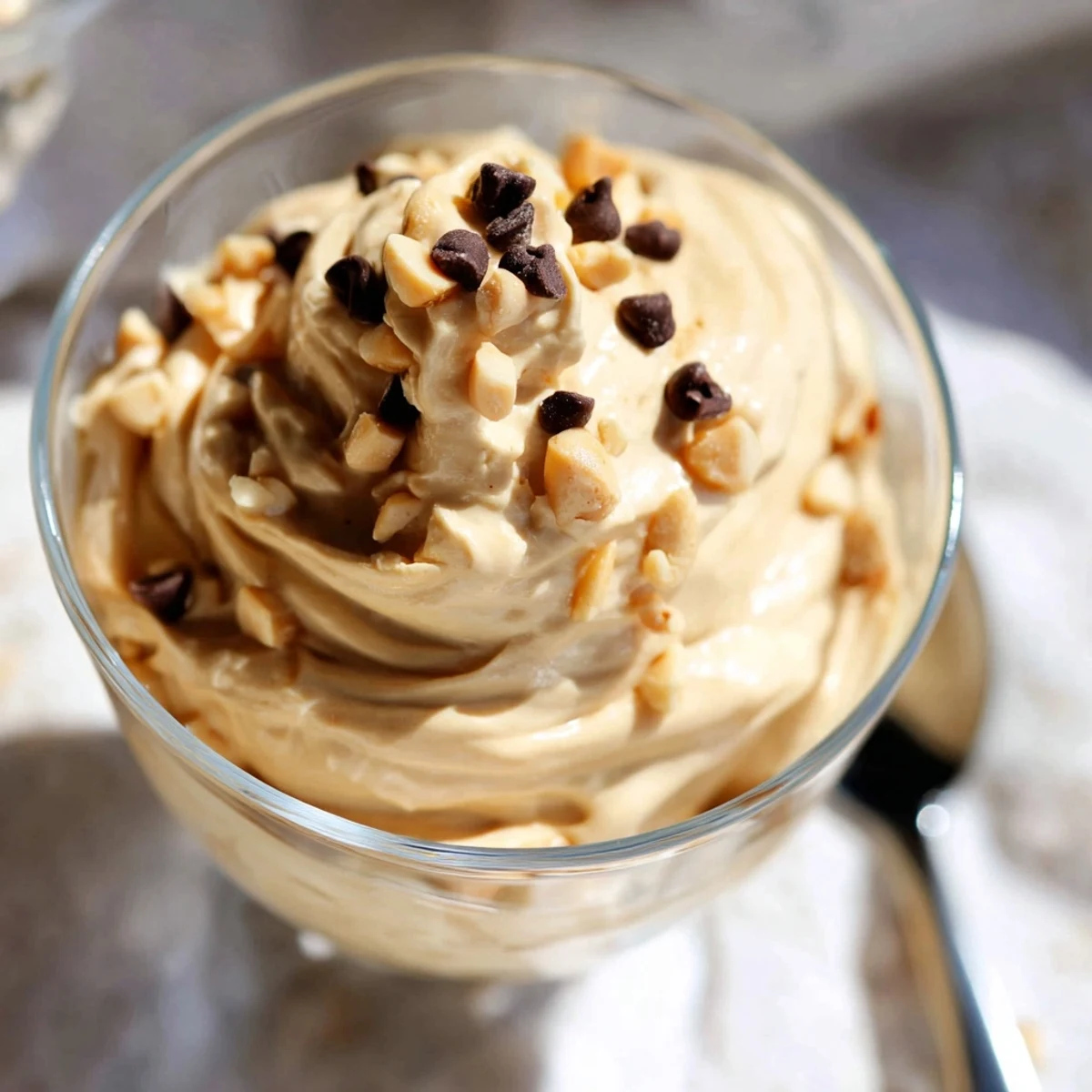 Creamy peanut butter and Cool Whip mousse topped with chopped peanuts in glass bowls