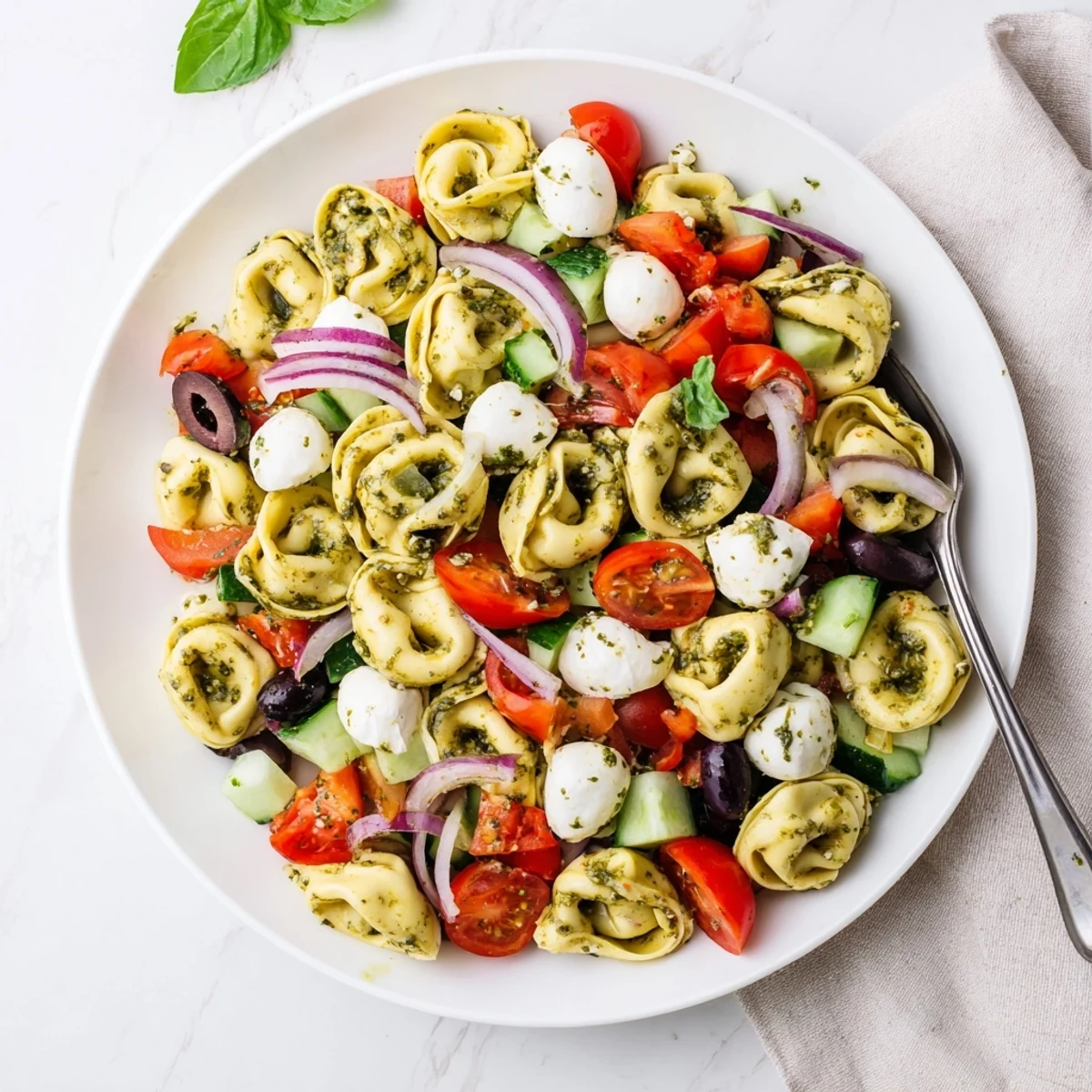Colorful tortellini pasta salad tossed with crisp vegetables and creamy mozzarella in Italian dressing