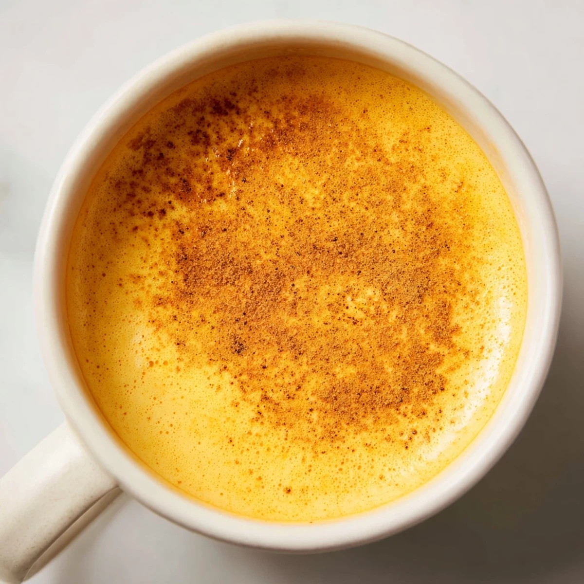 Creamy Goguma Latte topped with cinnamon in a cozy mug