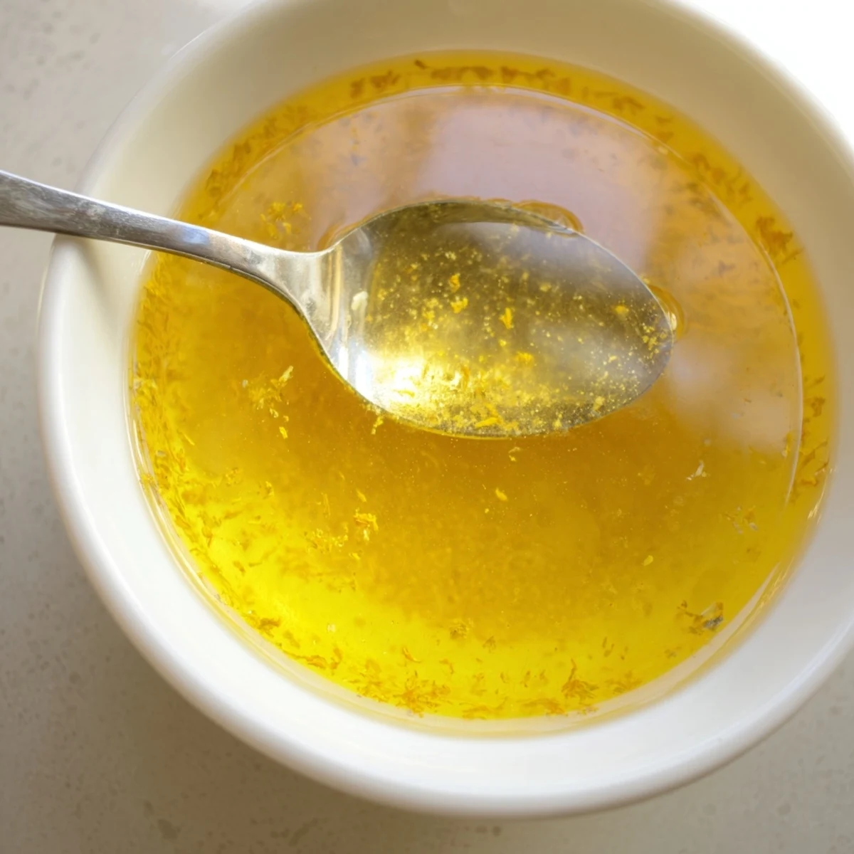 Golden homemade dandelion jelly spread on toasted bread with fresh flowers