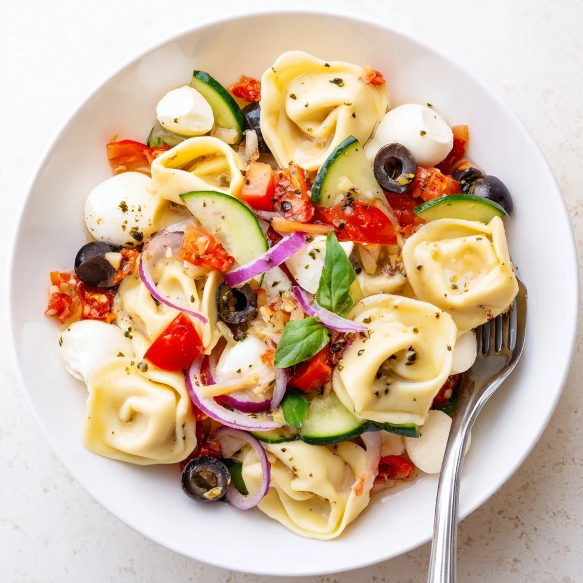 Creamy Tortellini Pasta Salad tossed in tangy Italian dressing, cucumber crunch.