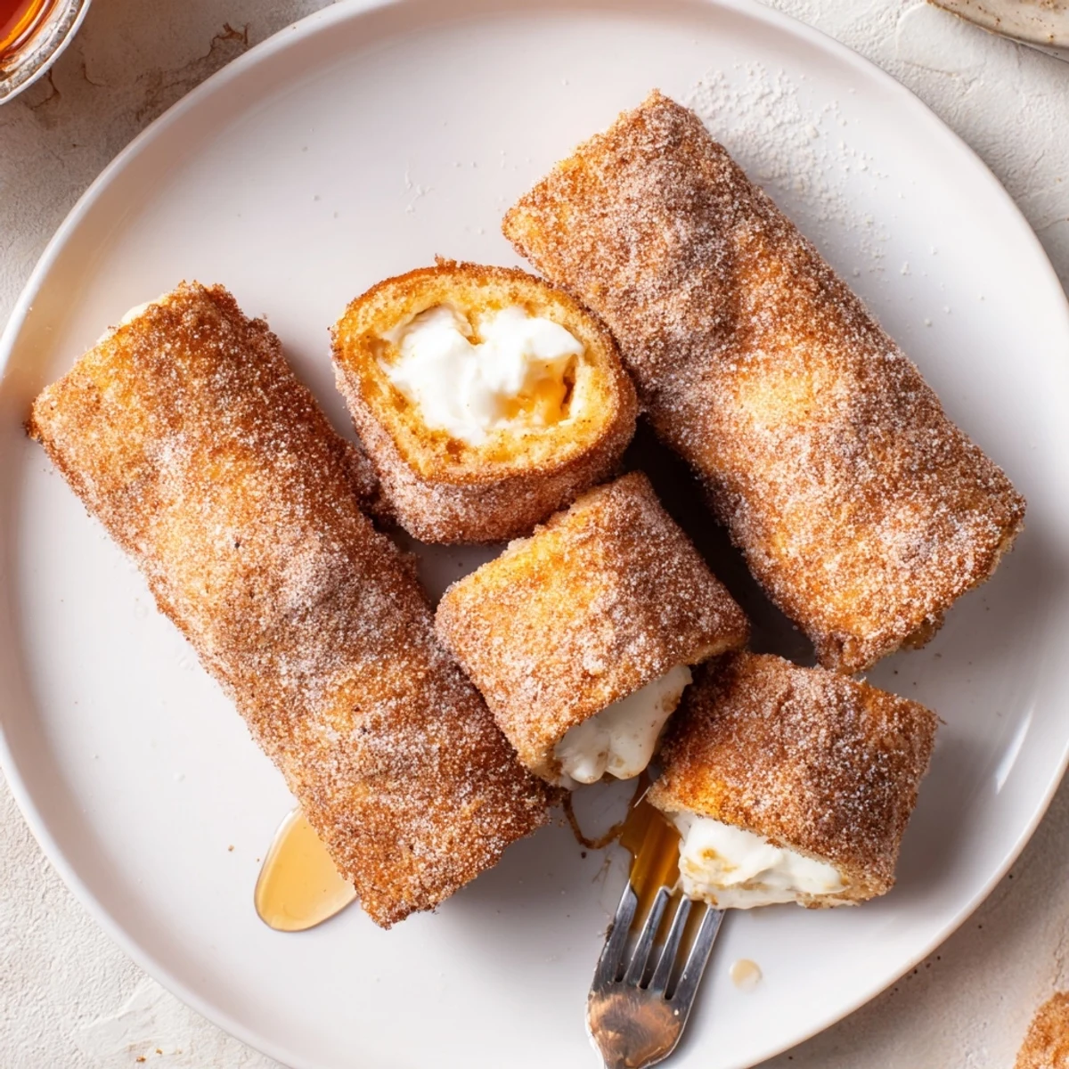 Warm Cinnamon Roll French Toast Roll Ups filled with sweet cream cheese, handheld