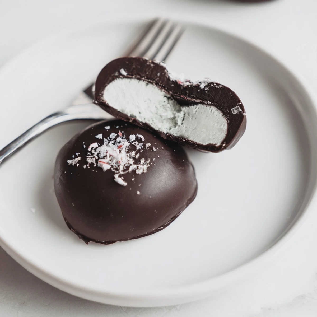 Fork-dipped Peppermint Patties resting on cooling rack, smooth mint center.