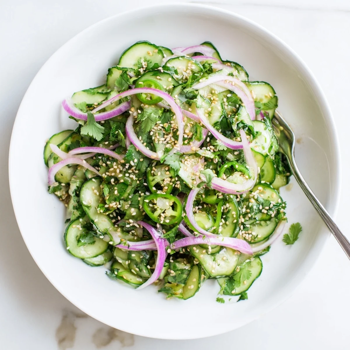 Vibrant honey lime cucumber salad bowl with thinly sliced cucumbers tossed in sweet and tangy honey lime dressing topped with fresh cilantro