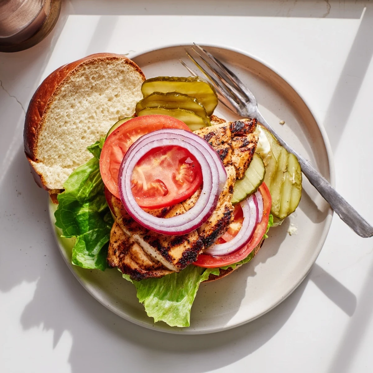 Golden-brown grilled Savory Spiced Chicken Sandwiches stacked with fresh lettuce and sliced tomatoes on toasted buns