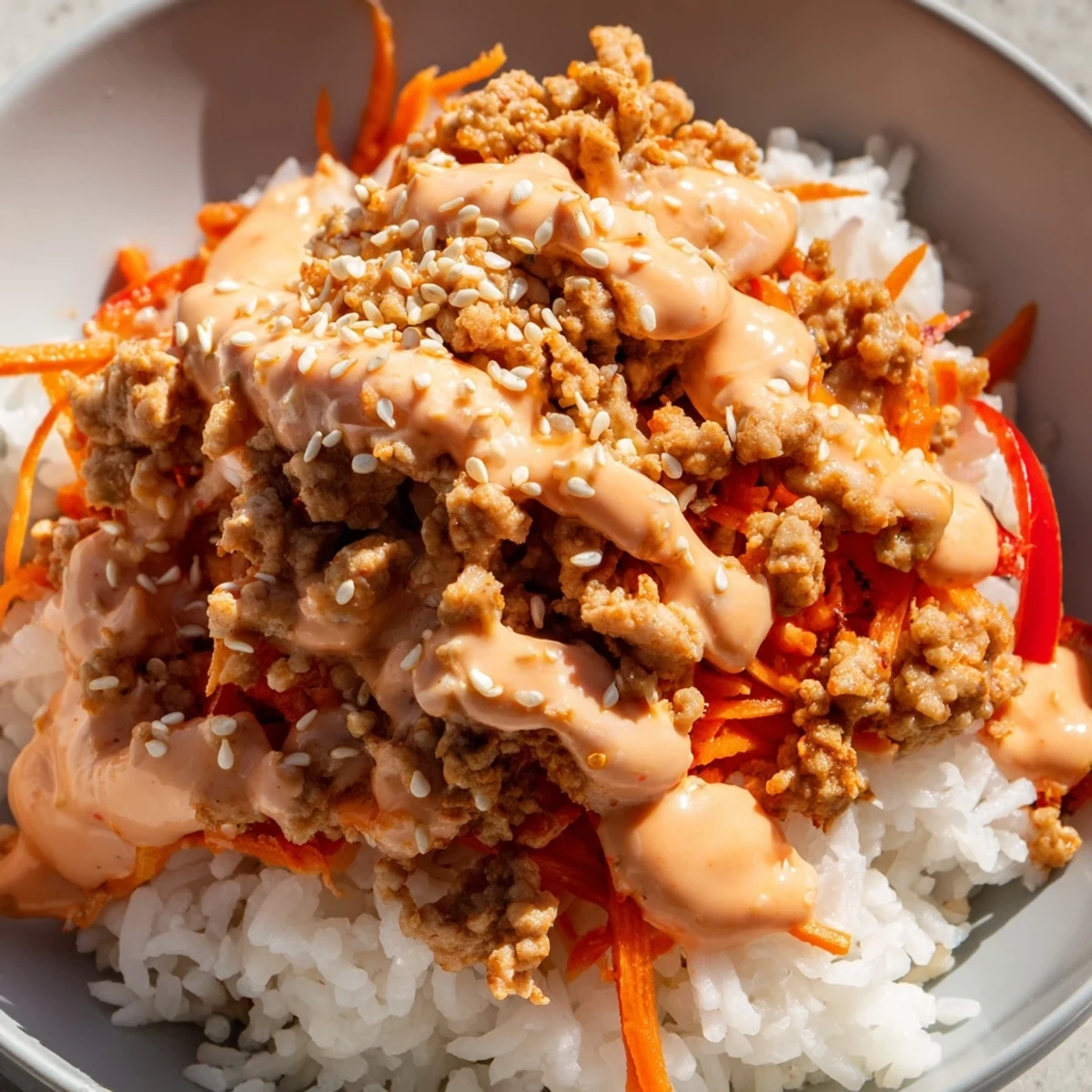 Hearty ground turkey rice bowls drizzled with spicy creamy bang bang sauce and crisp vegetables