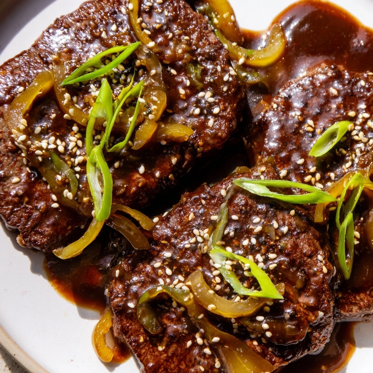 Juicy Asian-inspired cube steak draped in rich sauce beside steamed jasmine rice
