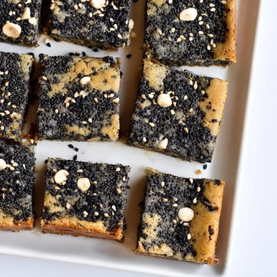 Freshly baked Black Sesame Blondies cut into squares, showing a chewy interior and rich, nutty aroma.